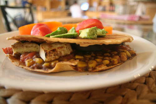 A wrap stuffed with beans, corn, eggplant, and tomato.