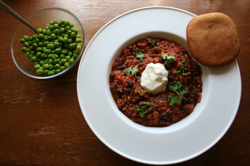 The chili with a dollop of sour cream and cilantro, and a side of buttered peas and...