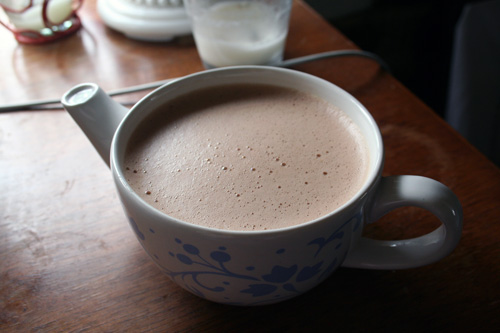 A cup of hot cocoa made with coconut milk and some cinnamon.