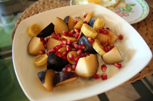 Pomegranate seeds, a baby banana, sultanas, and some plums